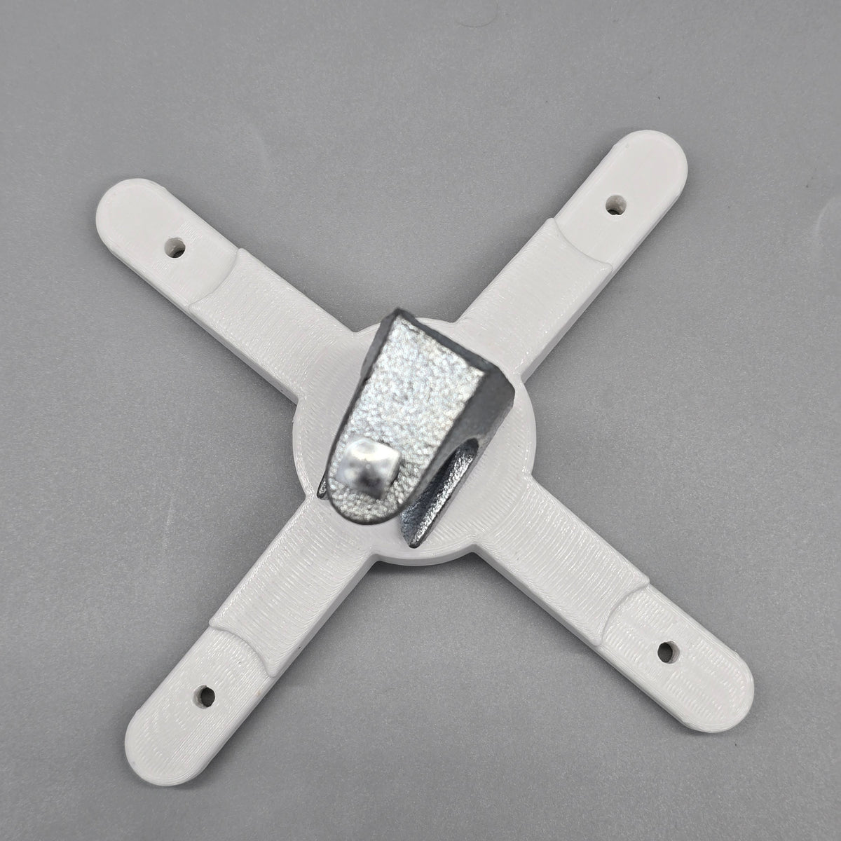 White plastic bracket with a central metallic component on a gray background